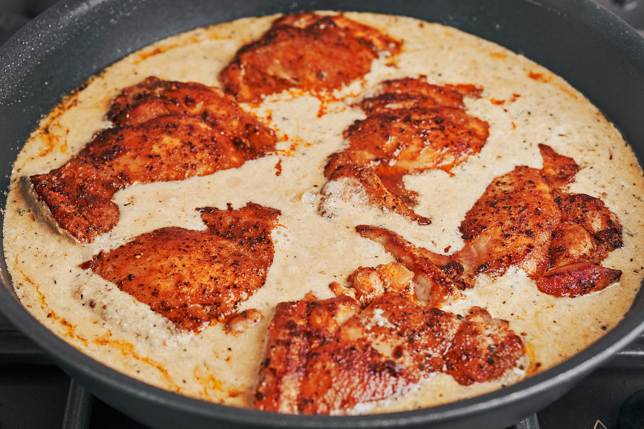 chicken thighs nestled back into the creamy skillet sauce to finish cooking