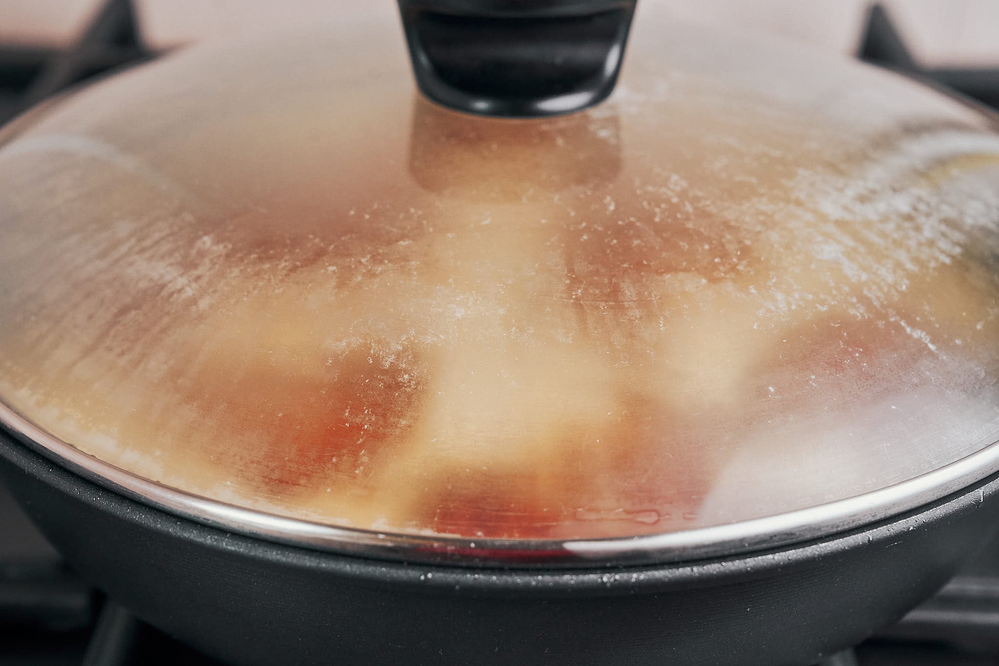 covering the skillet so the chicken can simmer gently in the creamy sauce
