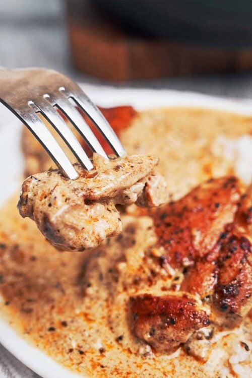 a forkful of tender creamy Dijon chicken straight from the plate