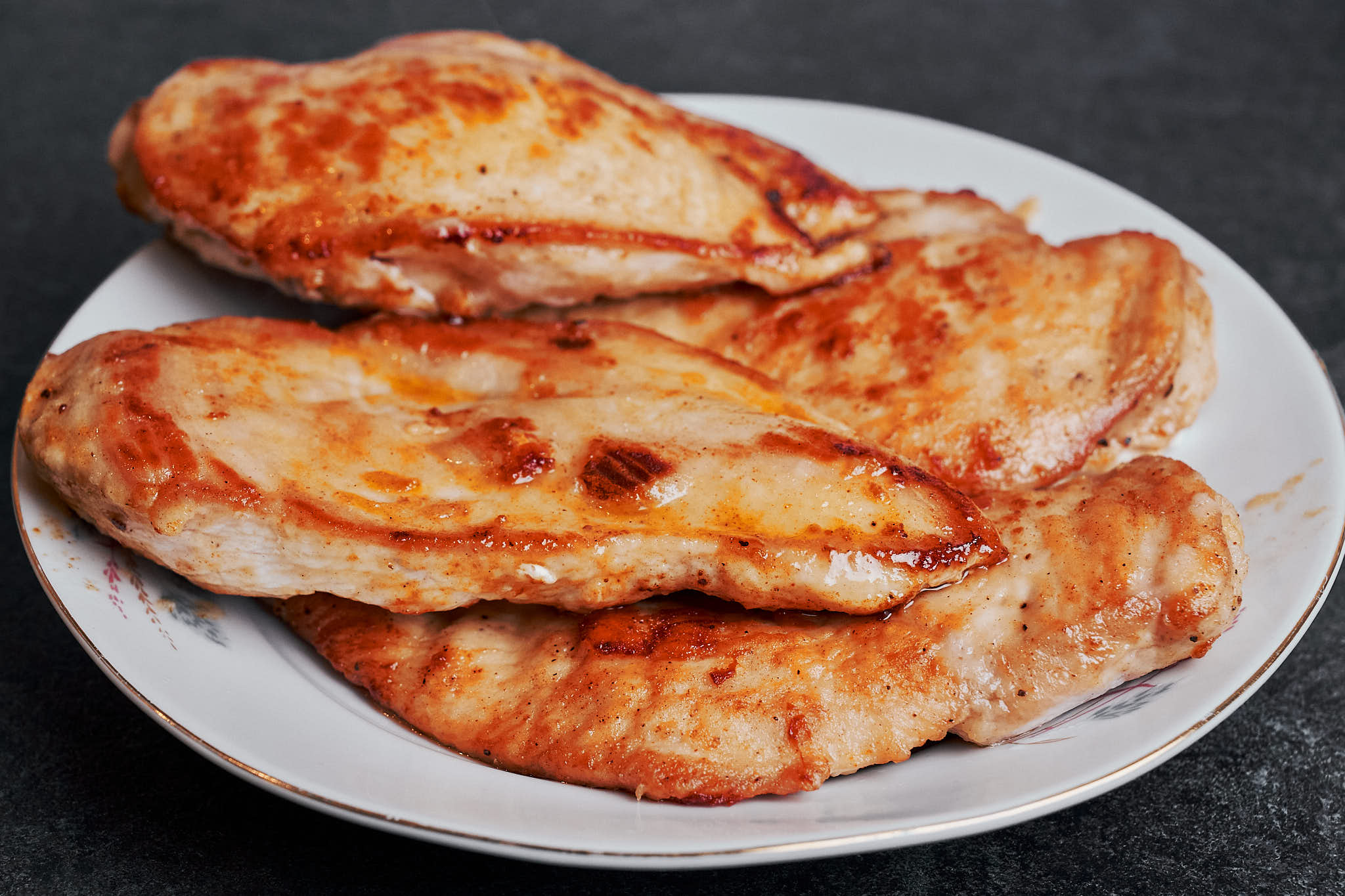 golden pan seared chicken cutlets resting on a plate