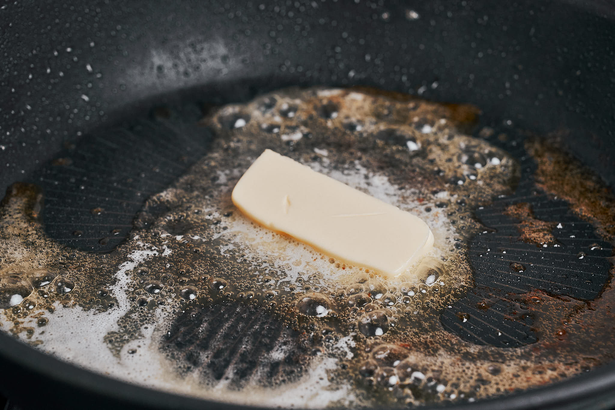 a pat of butter melting in the skillet before making the creamy lemon sauce