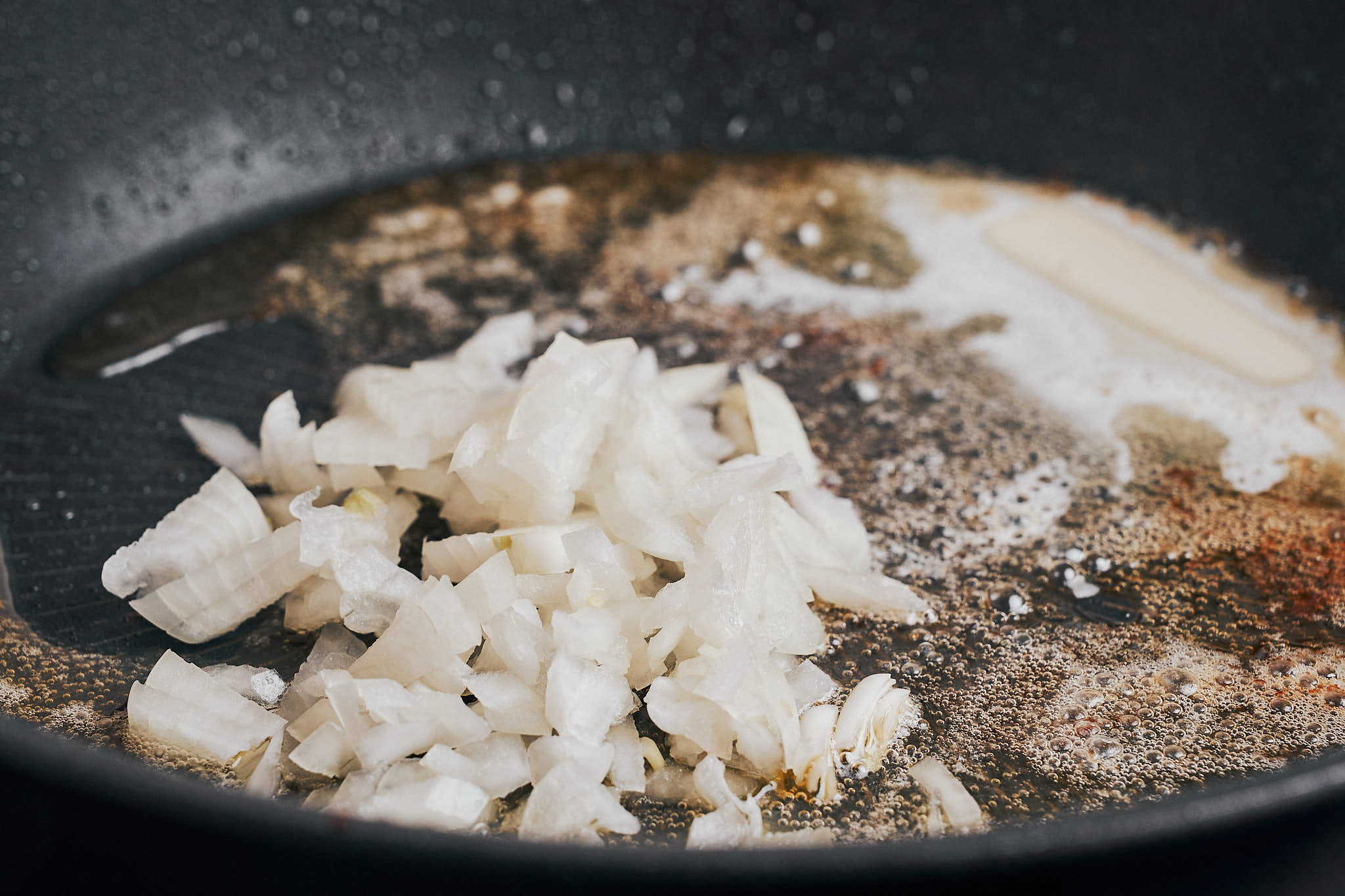 diced onion sautéing in butter to build the base of the lemon cream sauce