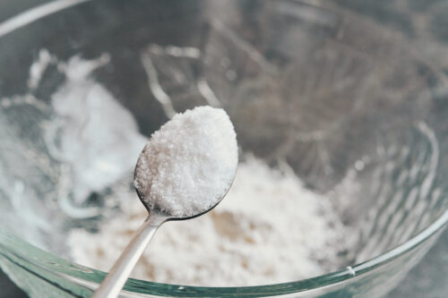 adding salt to the flour mixture to season the coating for creamy lemon chicken