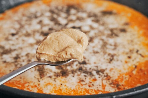 adding Dijon mustard to the creamy spinach chicken sauce