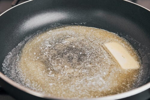 starting the mushrooms by melting butter in the pan