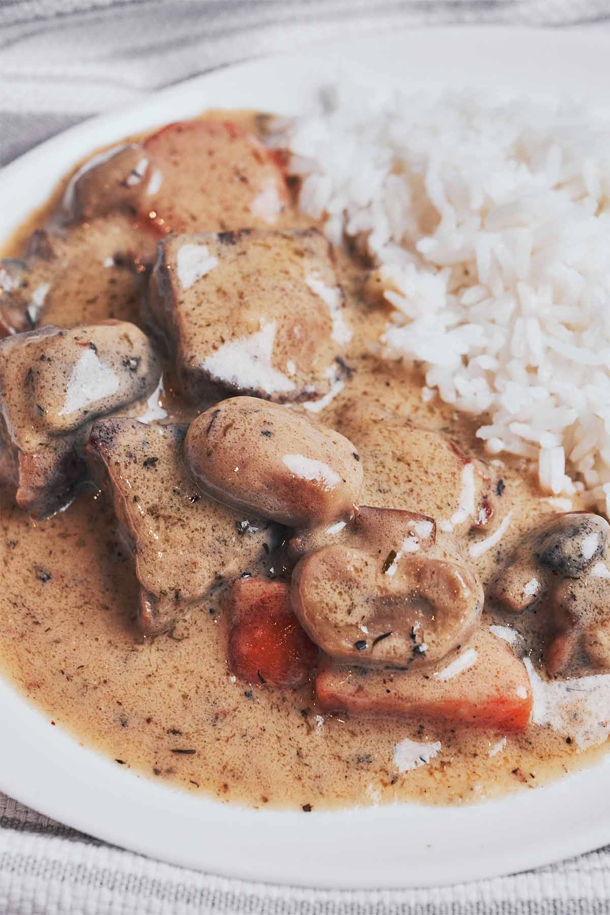 creamy beef stew with tender chunks of beef, mushrooms and carrots served over rice
