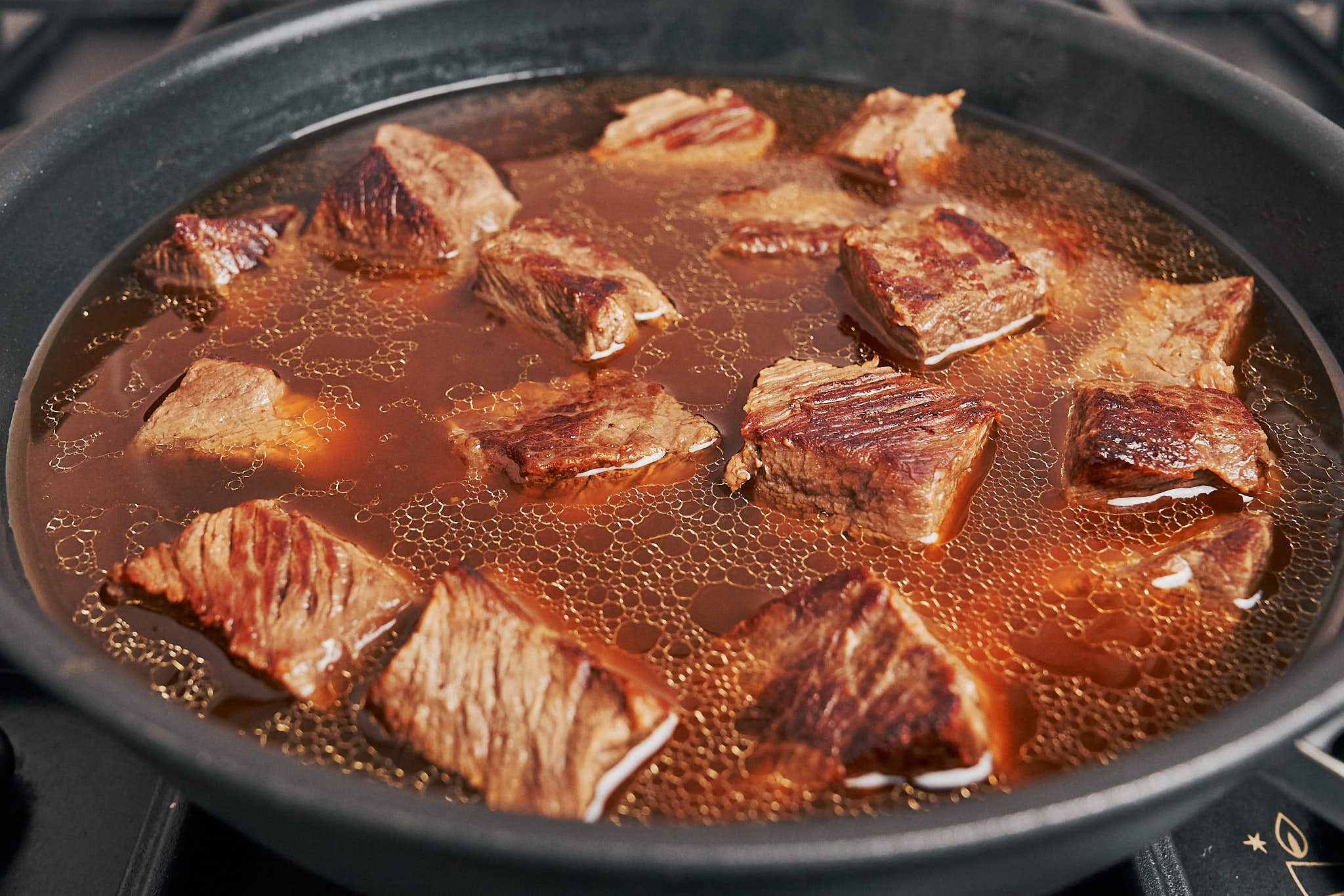 beef slowly cooking in the broth during the stew process