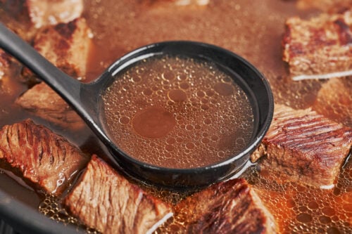 ladling flavorful broth to prepare the cream sauce