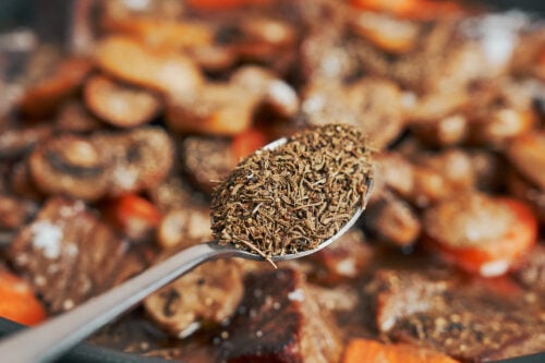 adding thyme to give the stew a warm herbal flavor