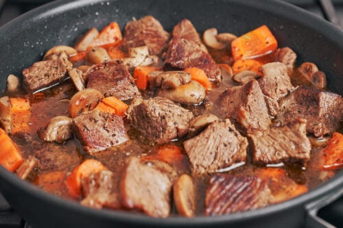 seasoned beef stew with mushrooms and carrots simmering together