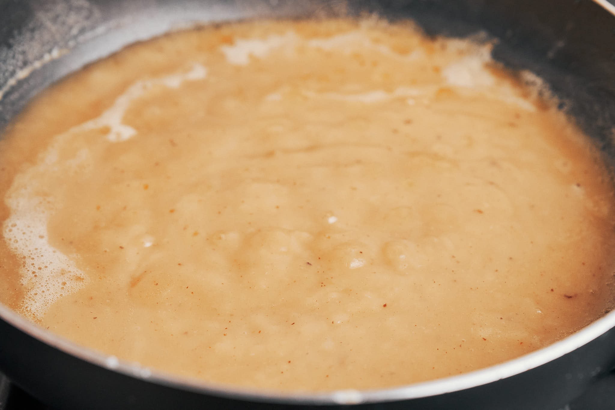 the sauce base thickening as the roux cooks