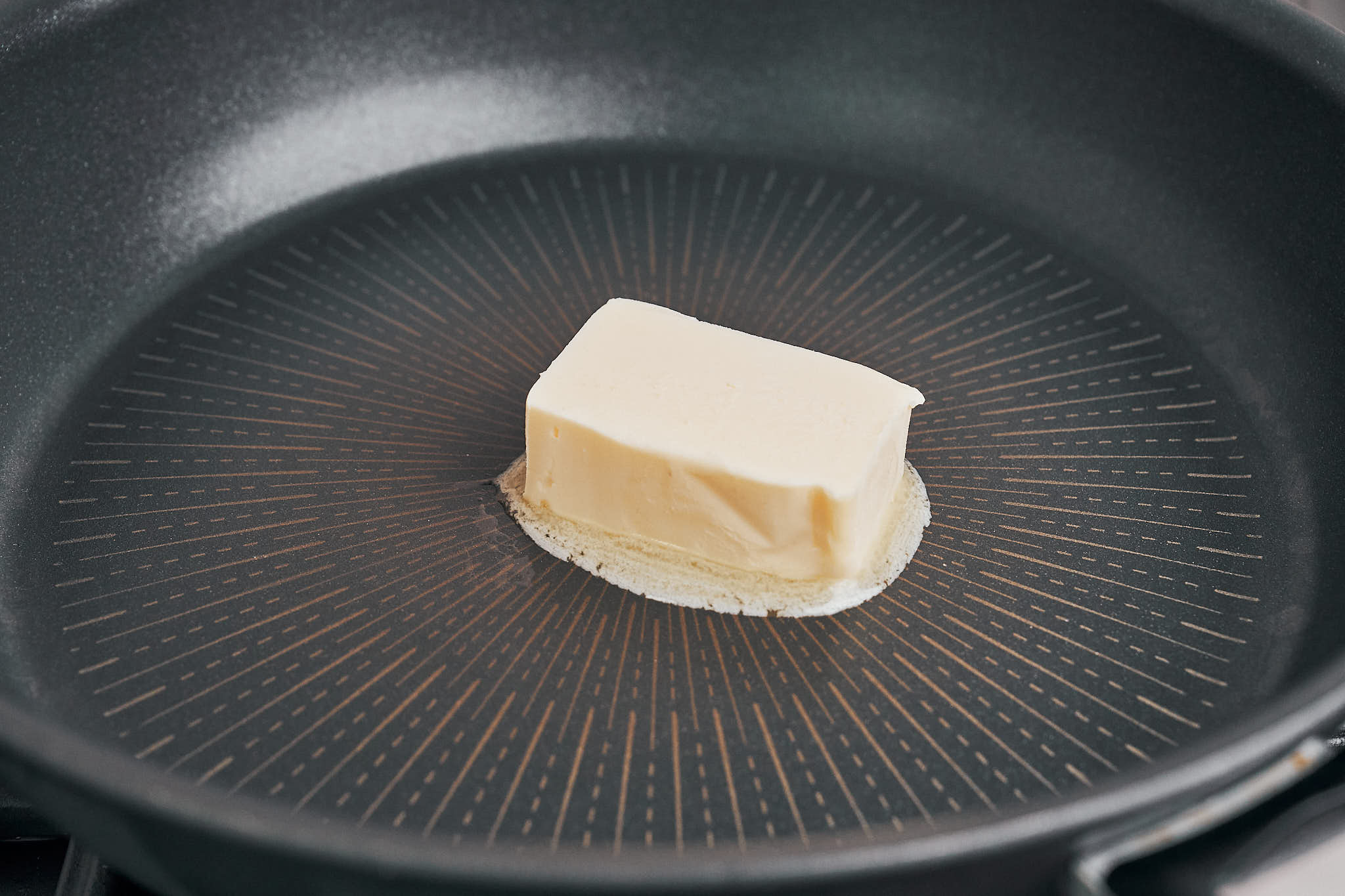 butter melting in a hot pan before searing the beef pieces