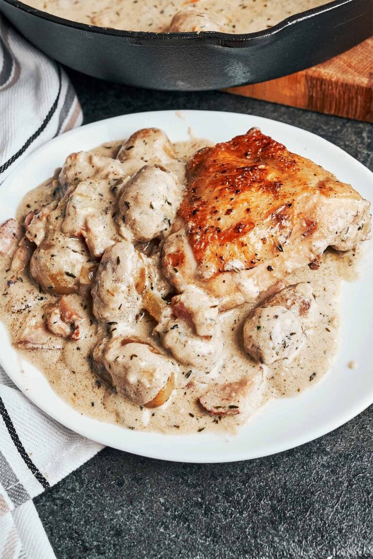 Creamy French chicken with potatoes and bacon in a rich Dijon white wine sauce, served warm with golden chicken thighs and tender potatoes.