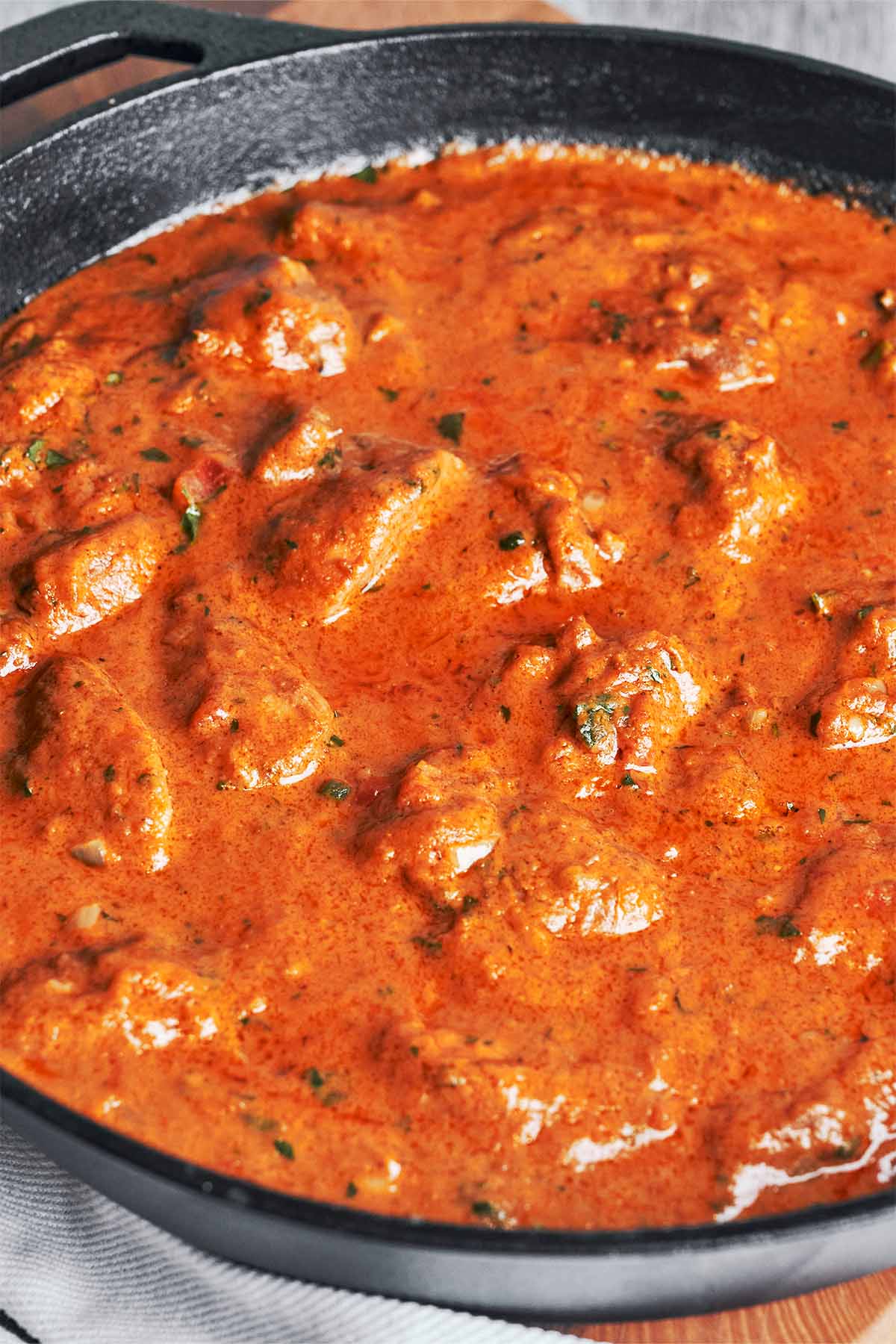 Creamy peanut butter chicken cooking in a skillet with a rich, savory sauce