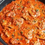 Creamy butter chicken in a skillet with tender chicken pieces, fresh parsley, and a rich tomato cream sauce