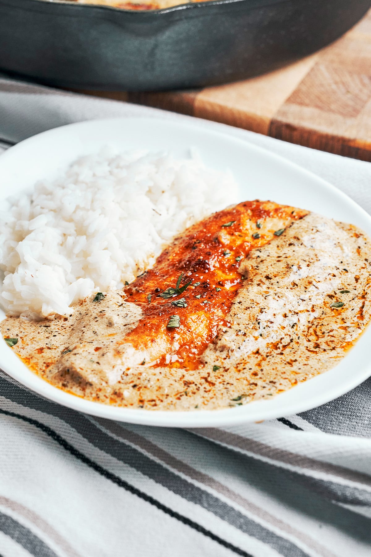 Creamy herb chicken on a plate with rice, coated in a rich, creamy herb sauce