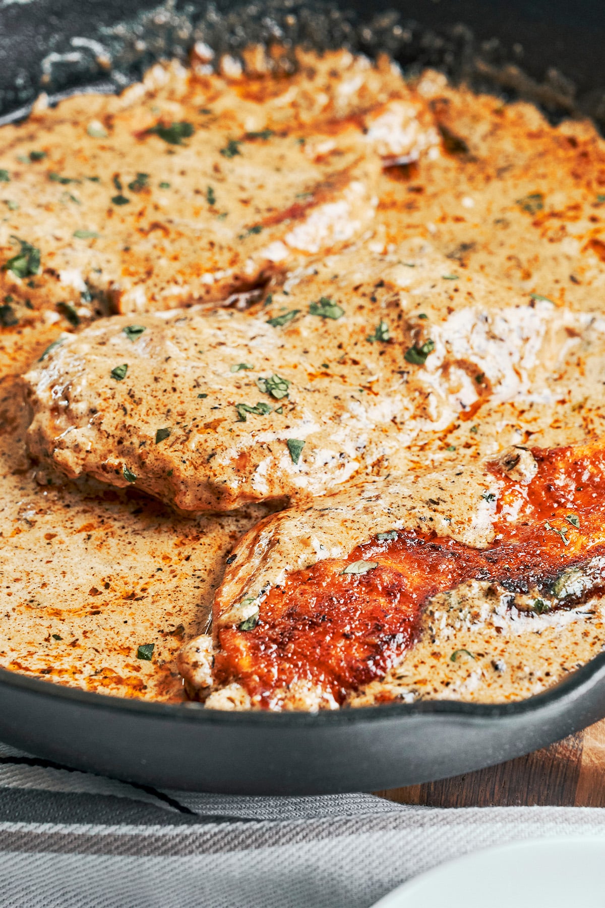 Finished creamy herb chicken in a skillet with tender chicken in a rich, creamy herb sauce