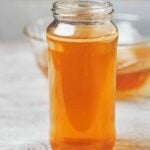 clear golden homemade chicken broth in a glass jar ready to use for soups and cooking