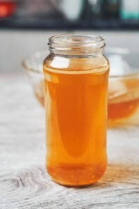 clear golden homemade chicken broth in a glass jar ready to use for soups and cooking