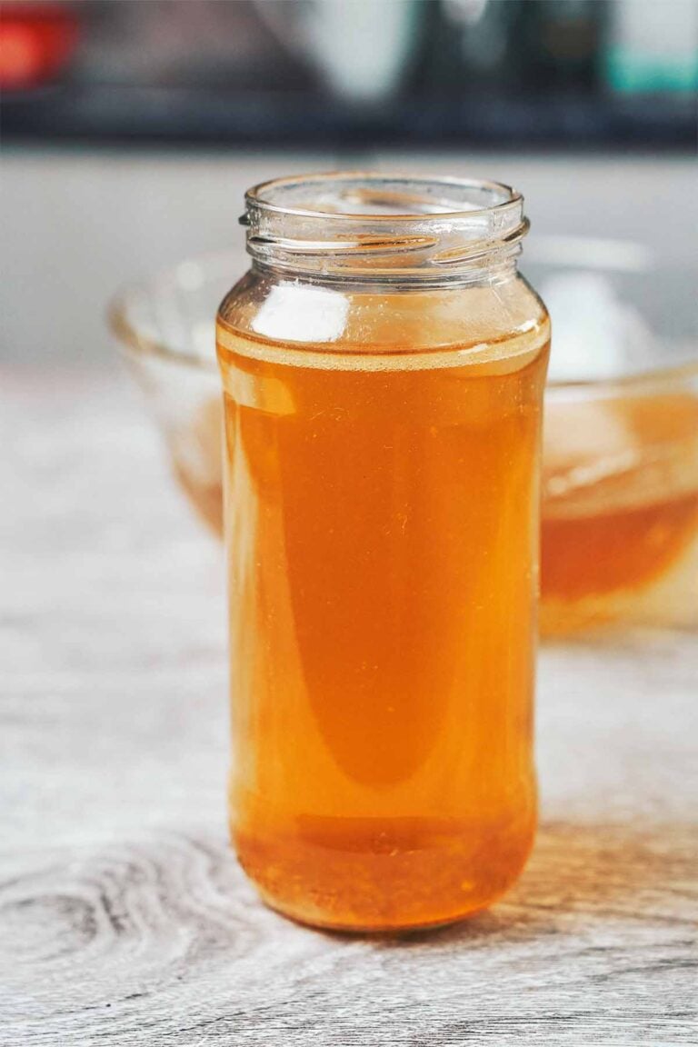 clear golden homemade chicken broth in a glass jar ready to use for soups and cooking
