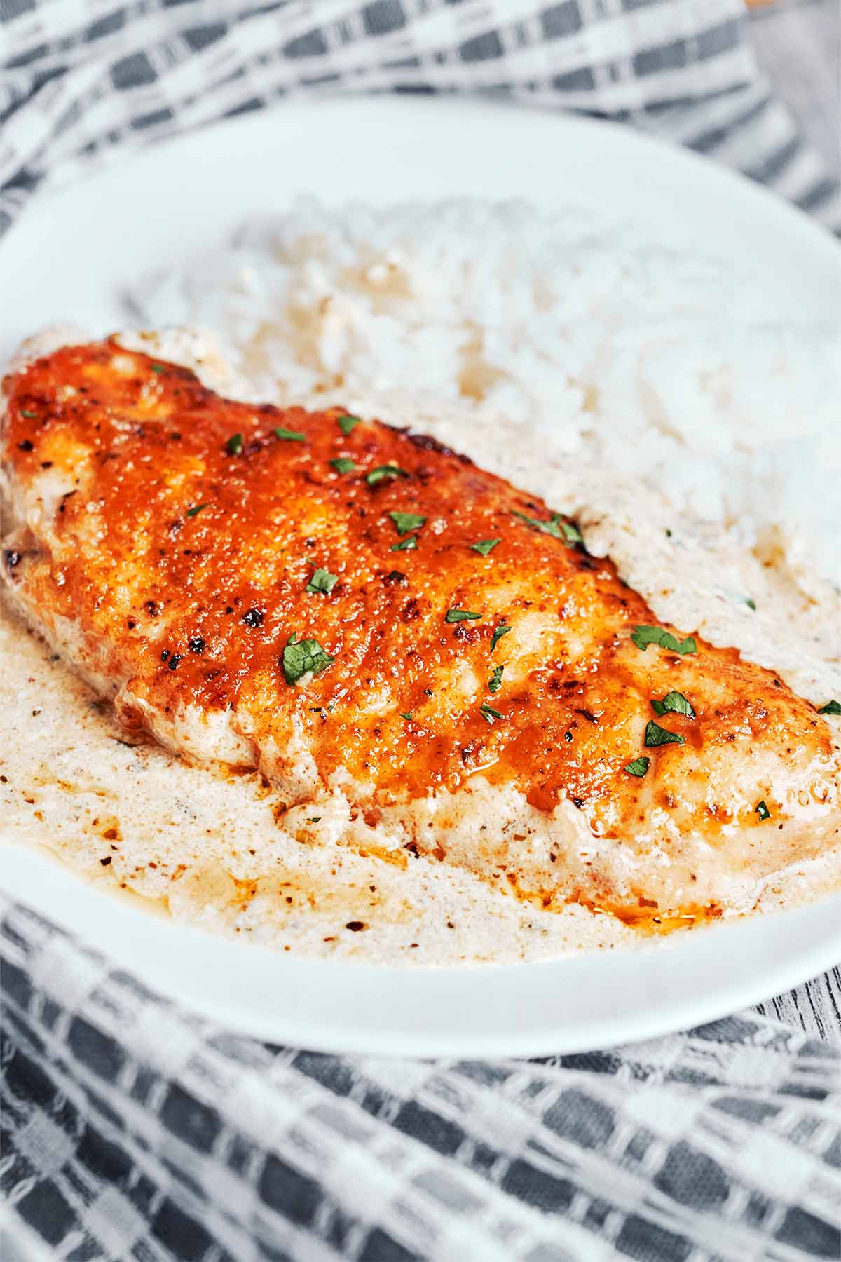 Creamy Alfredo chicken served on a plate with fluffy rice and rich garlic Parmesan sauce.