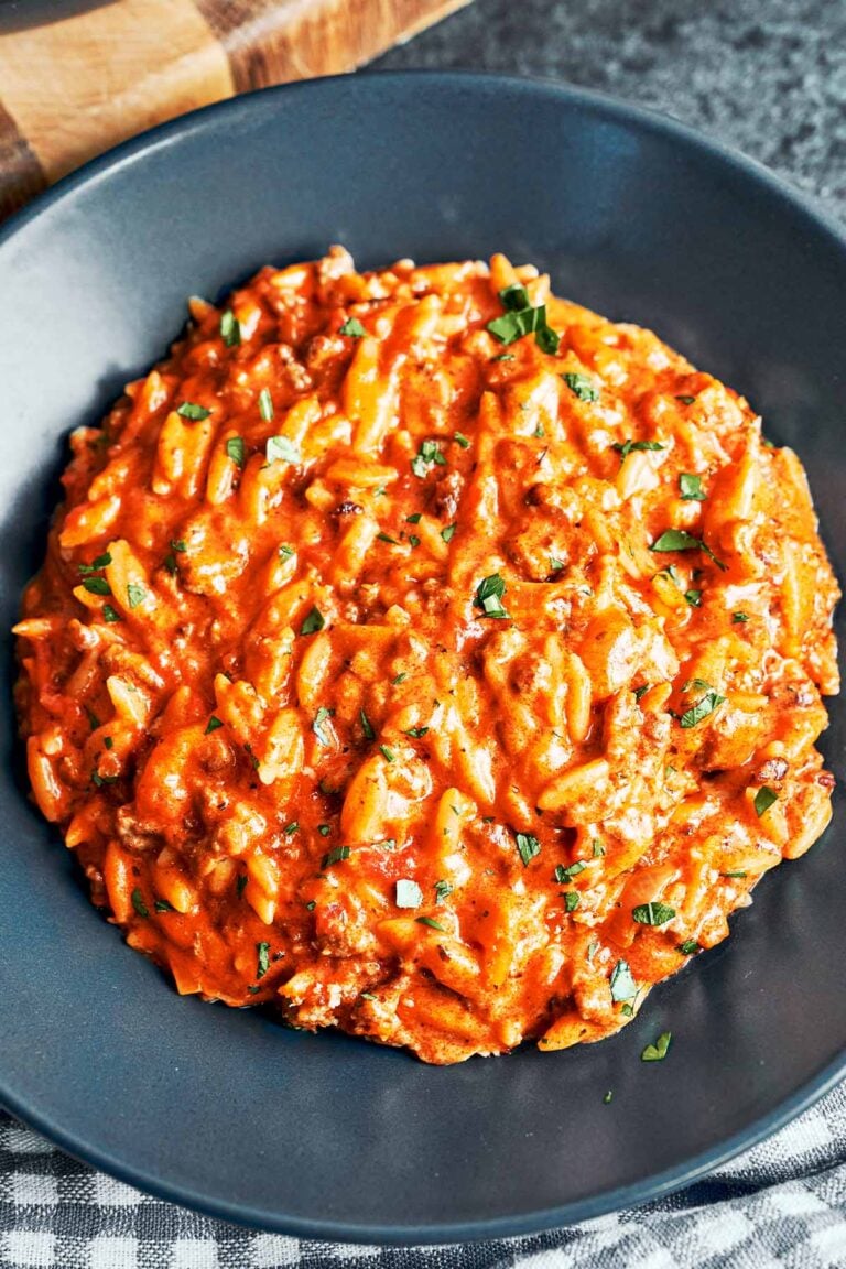Creamy ground beef orzo served in a bowl with rich tomato-cream sauce, Parmesan, and fresh parsley.