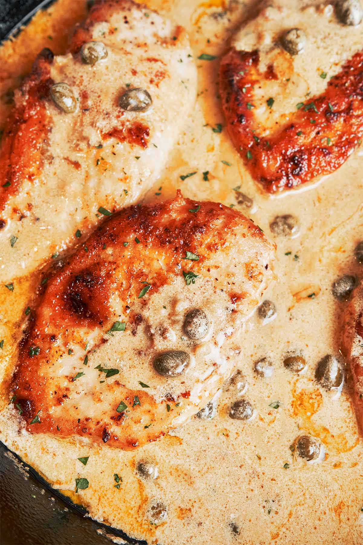 Creamy chicken piccata with golden pan-seared chicken in a silky lemon caper cream sauce, finished with parsley and lemon slices.