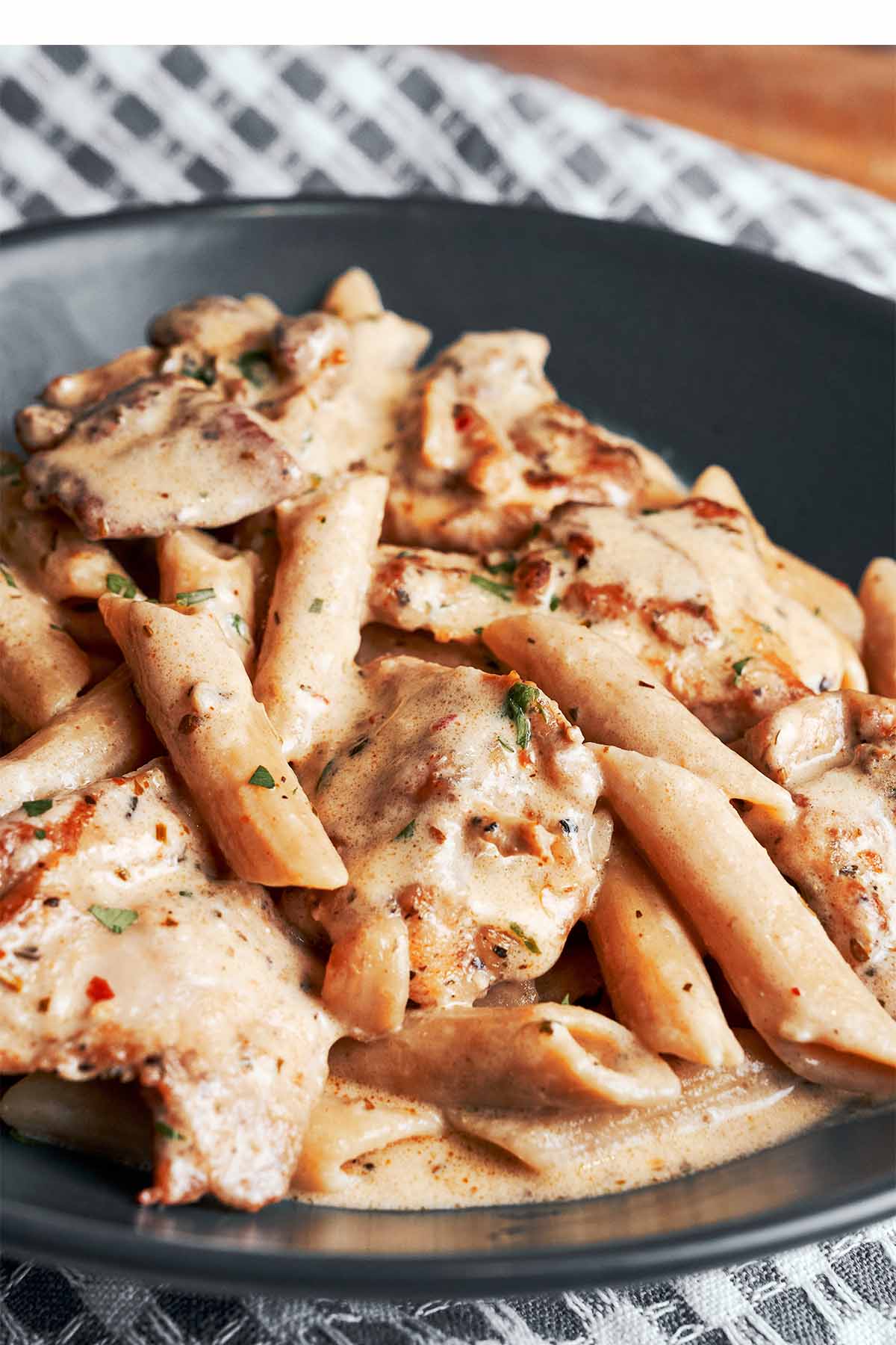 Creamy chicken pasta served in a bowl with juicy chicken pieces and penne in a silky Parmesan sauce