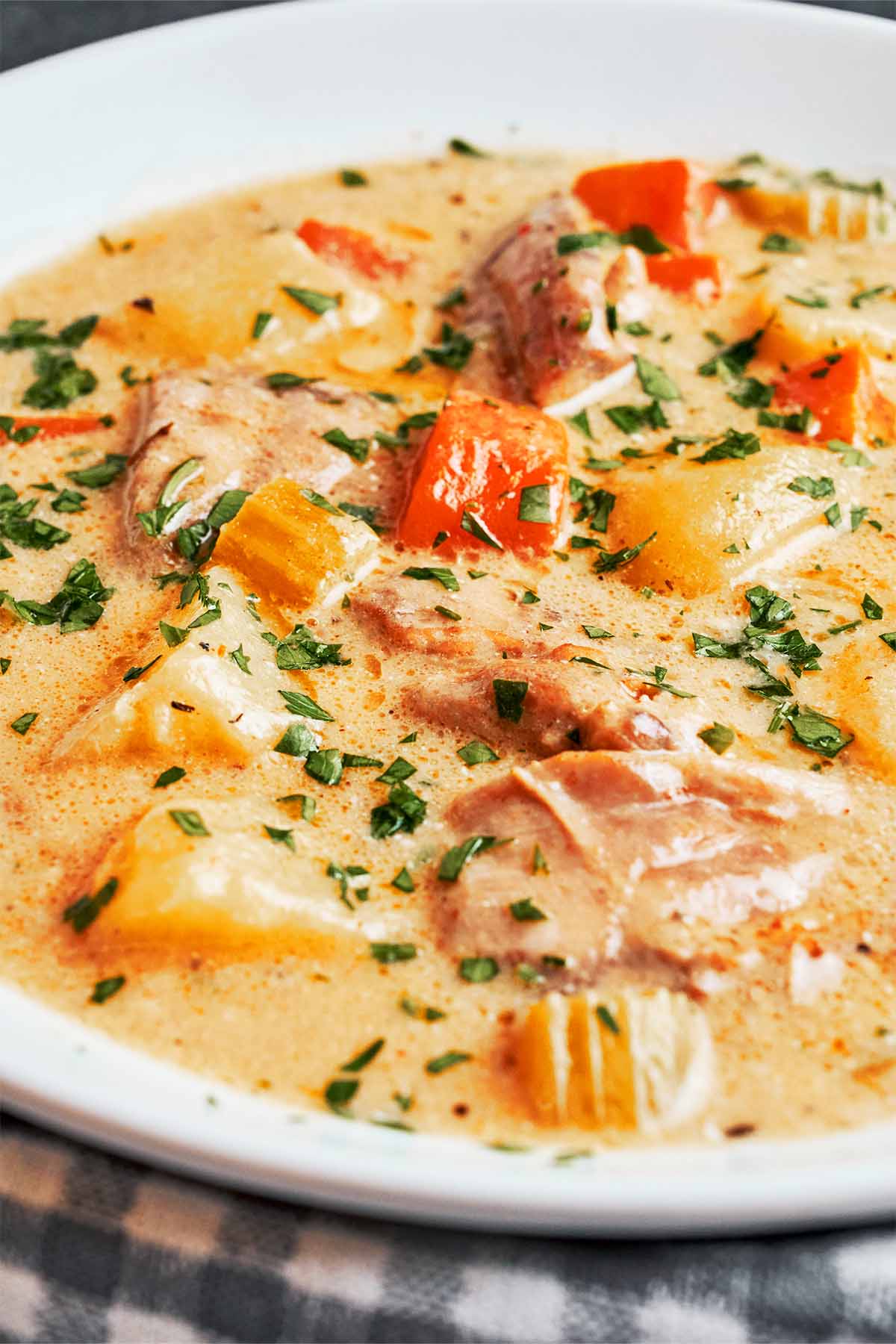 Creamy chicken soup with tender chicken, potatoes, carrots, celery, and fresh parsley.