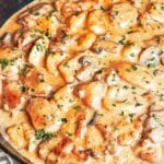 Creamy Chicken and Gnocchi in a cast iron skillet with tender chicken thighs, pillowy potato gnocchi, mushrooms, and silky Parmesan cream sauce.