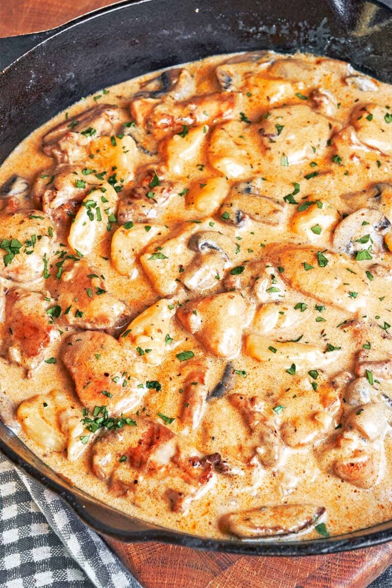 Creamy Chicken and Gnocchi in a cast iron skillet with tender chicken thighs, pillowy potato gnocchi, mushrooms, and silky Parmesan cream sauce.