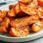 Crispy oven roasted potato wedges with deeply browned edges, smoky herb seasoning, and fresh rosemary
