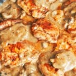 Smothered chicken with mushroom gravy in a skillet with juicy seared chicken thighs, tender mushrooms, and rich homemade gravy.