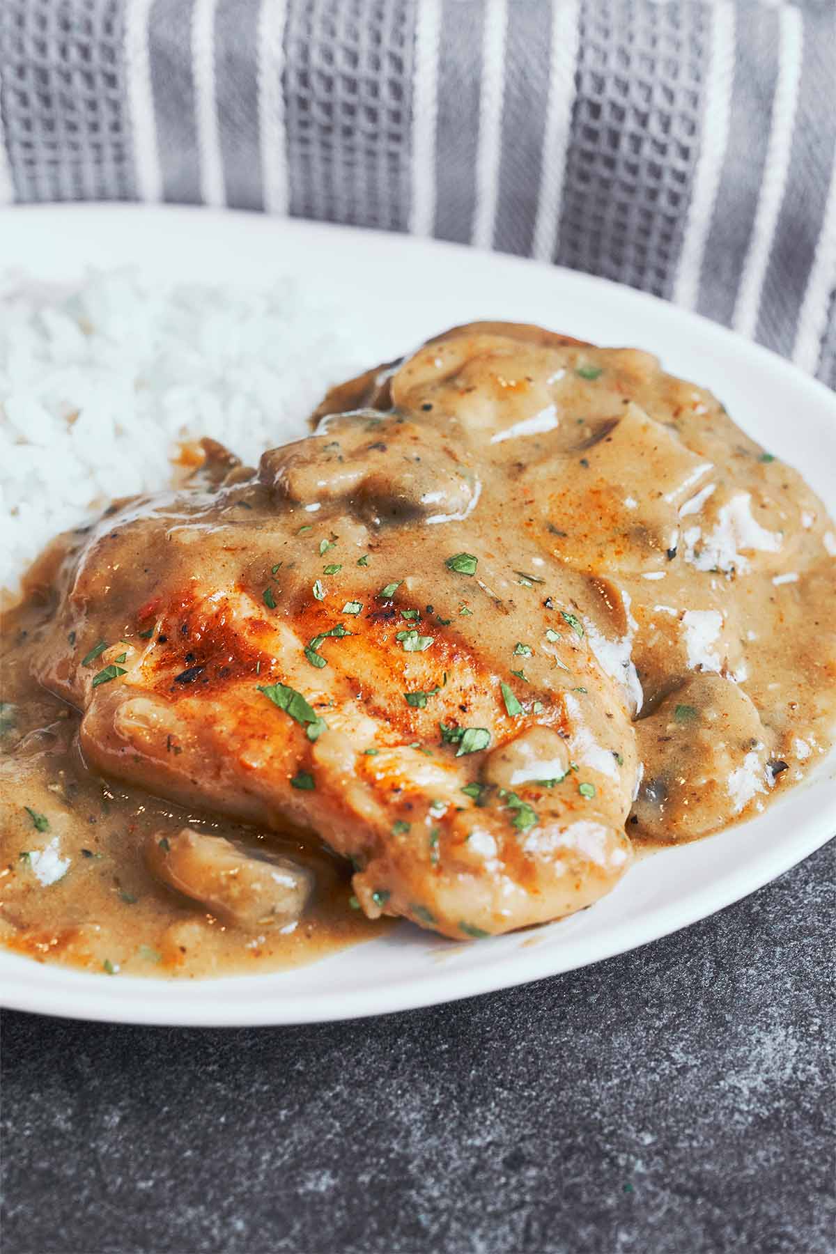 Golden seared chicken spooned with thick mushroom gravy and served with rice for a hearty homemade meal.