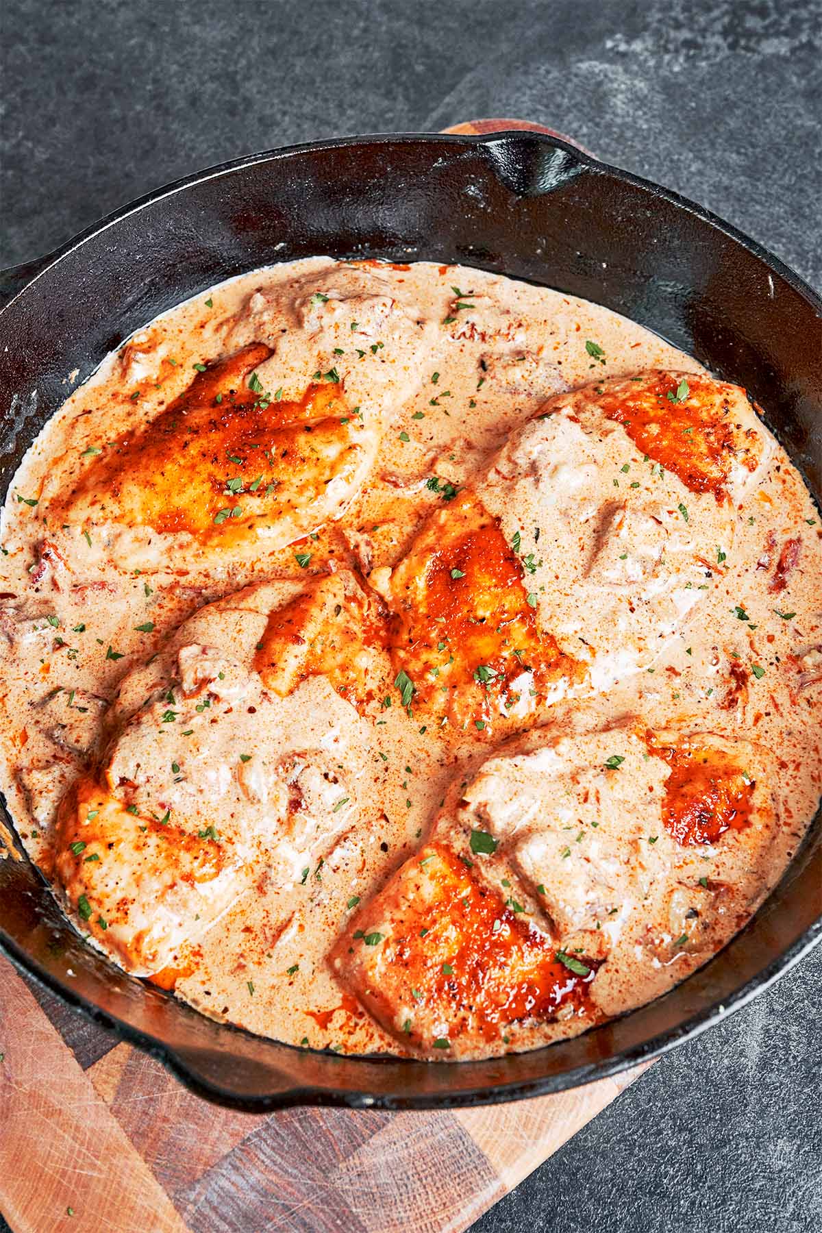 Creamy Cajun chicken with sun-dried tomatoes ready to serve in a skillet