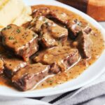 Beef Tips and Gravy with tender beef pieces in glossy brown gravy and mashed potatoes