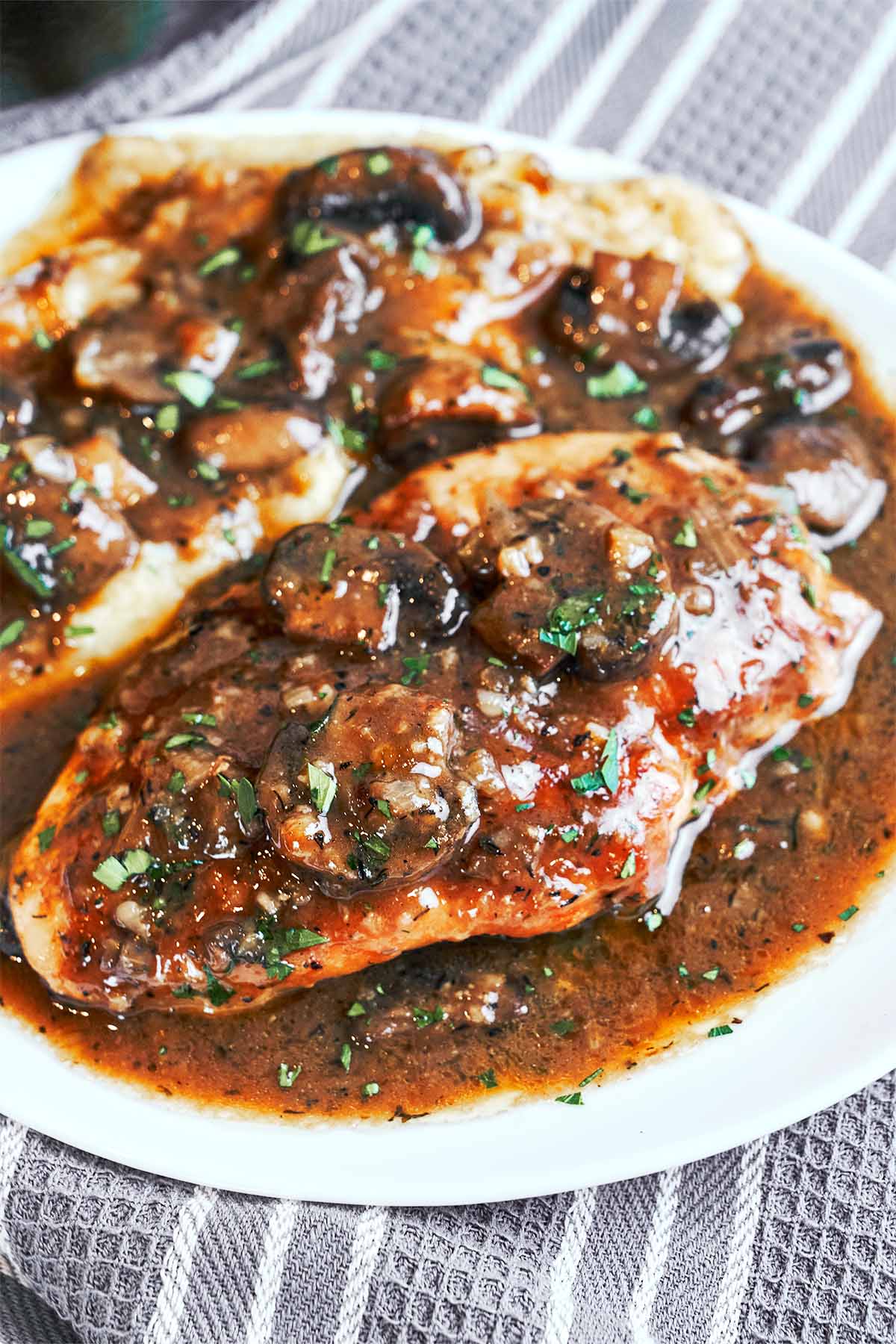 Juicy chicken cutlets covered in a glossy Marsala mushroom sauce with fresh parsley
