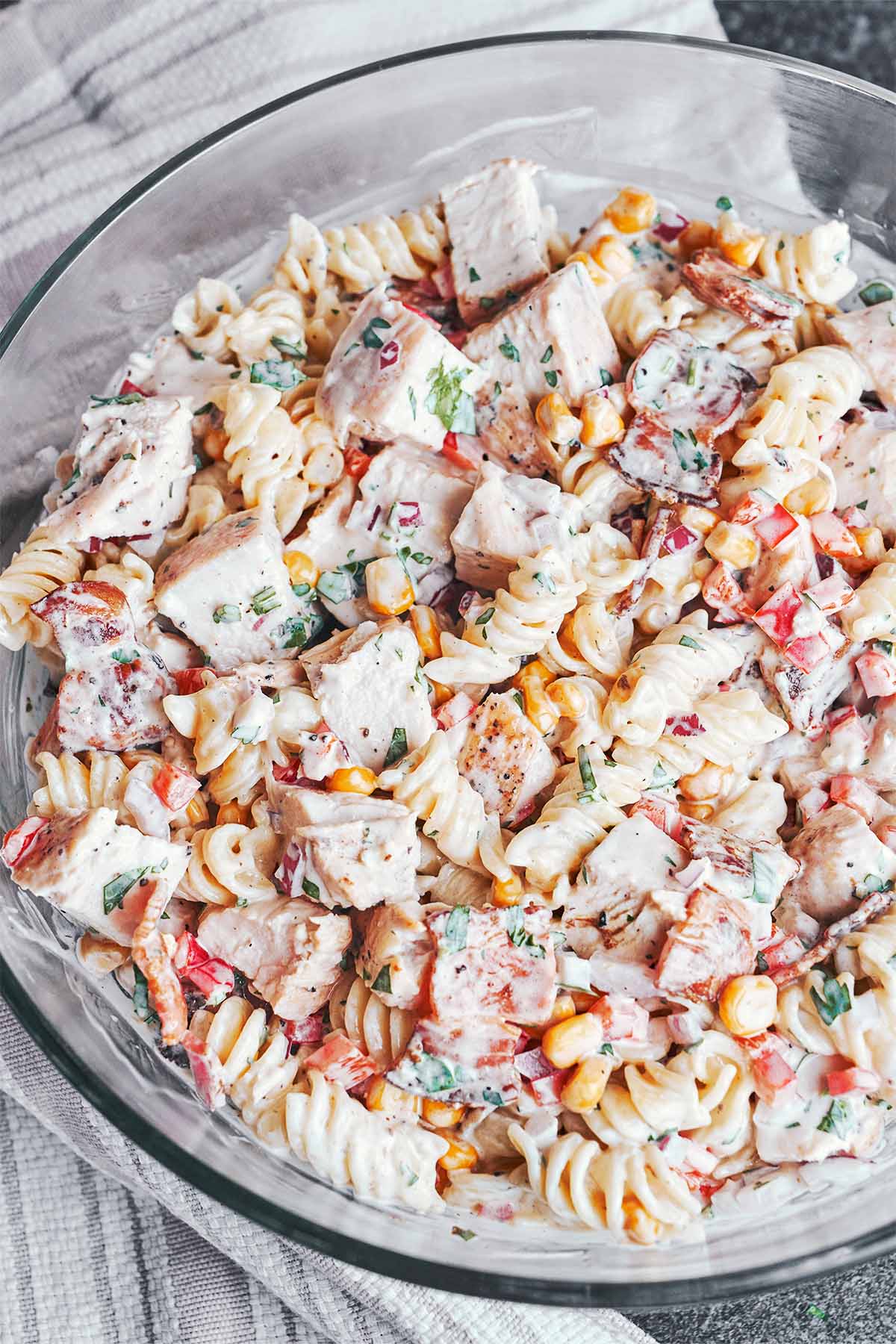 A big bowl of creamy fusilli tossed with golden chicken, crisp bacon, sweet corn, red pepper, and fresh parsley