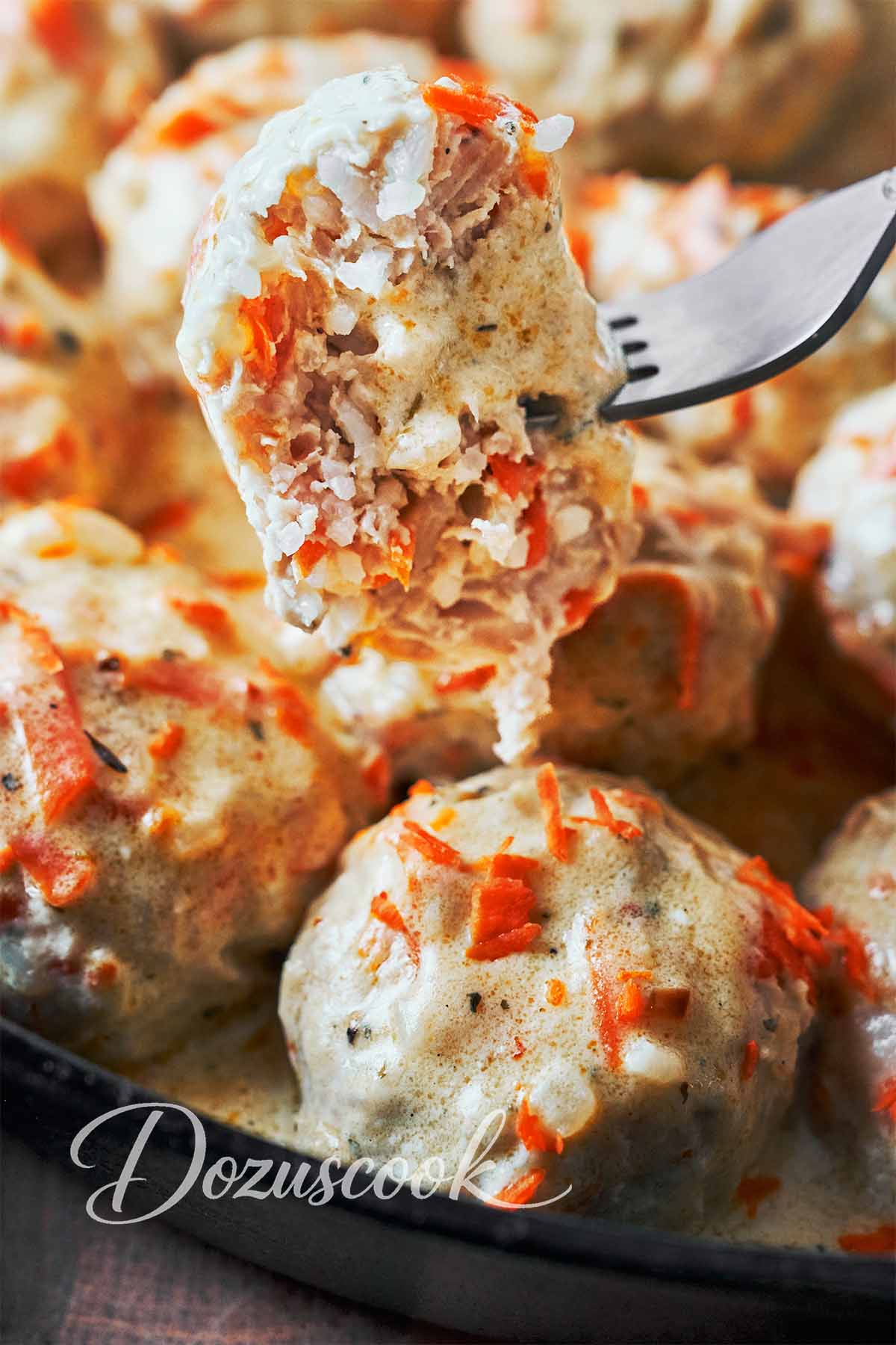 Chicken meatball on a fork showing the tender rice and chicken filling