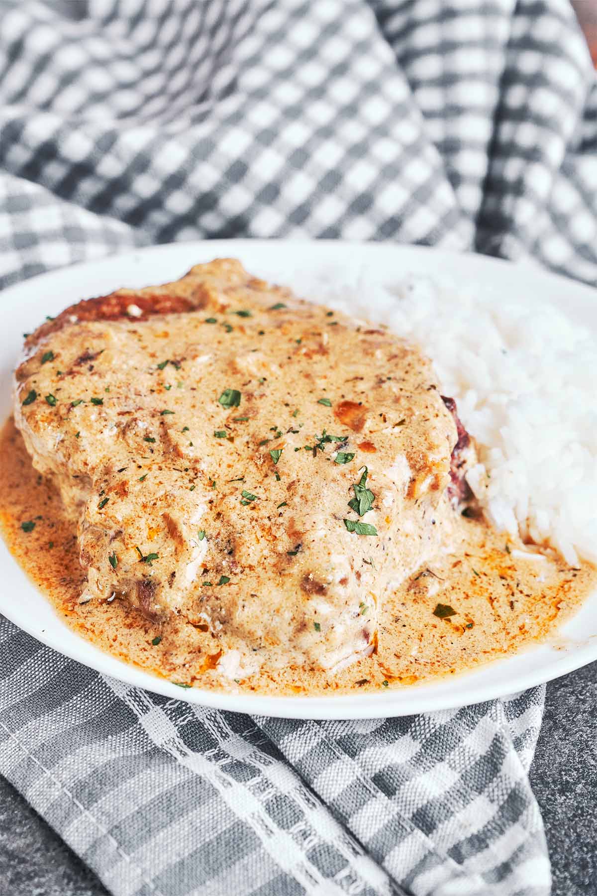 Tender bone-in pork chop covered in creamy Dijon sauce and served with fluffy white rice