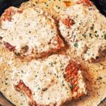 Creamy Dijon Pork Chops in a cast-iron skillet, covered in a rich mustard cream sauce and finished with parsley