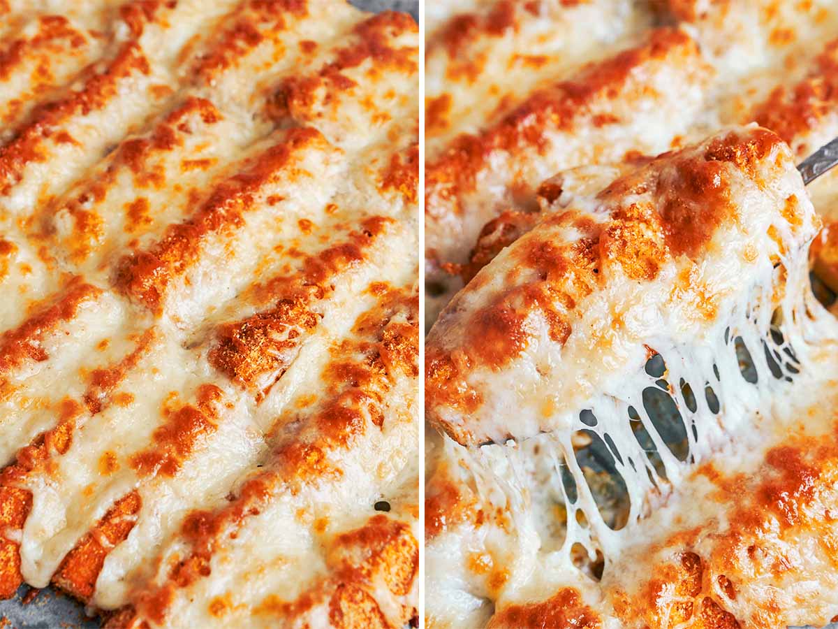 Golden baked zucchini wedges covered with bubbly melted mozzarella, with one piece lifted to show the stretchy cheese.