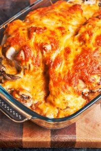 Easy baked chicken breast with a deeply golden cheese topping, mushrooms, and tender potatoes baked underneath.