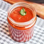 Homemade enchilada sauce with a smooth, silky texture served in a glass jar and ready for enchiladas.