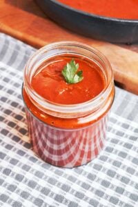 Homemade enchilada sauce with a smooth, silky texture served in a glass jar and ready for enchiladas.