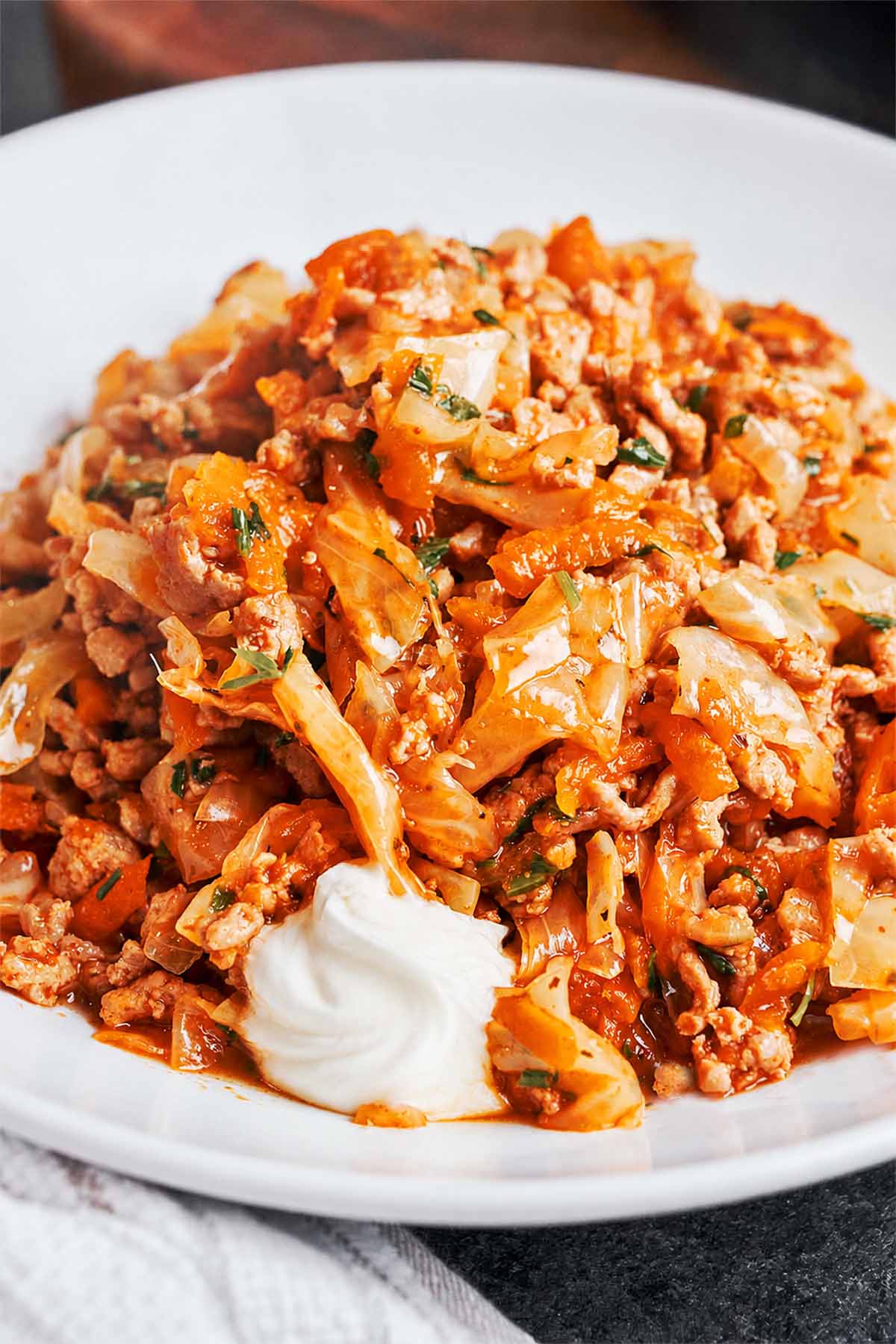 Warm cabbage and browned beef served with a spoonful of sour cream.