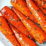 Honey garlic butter roasted carrots with caramelized edges, glossy glaze, and a sprinkle of fresh herbs