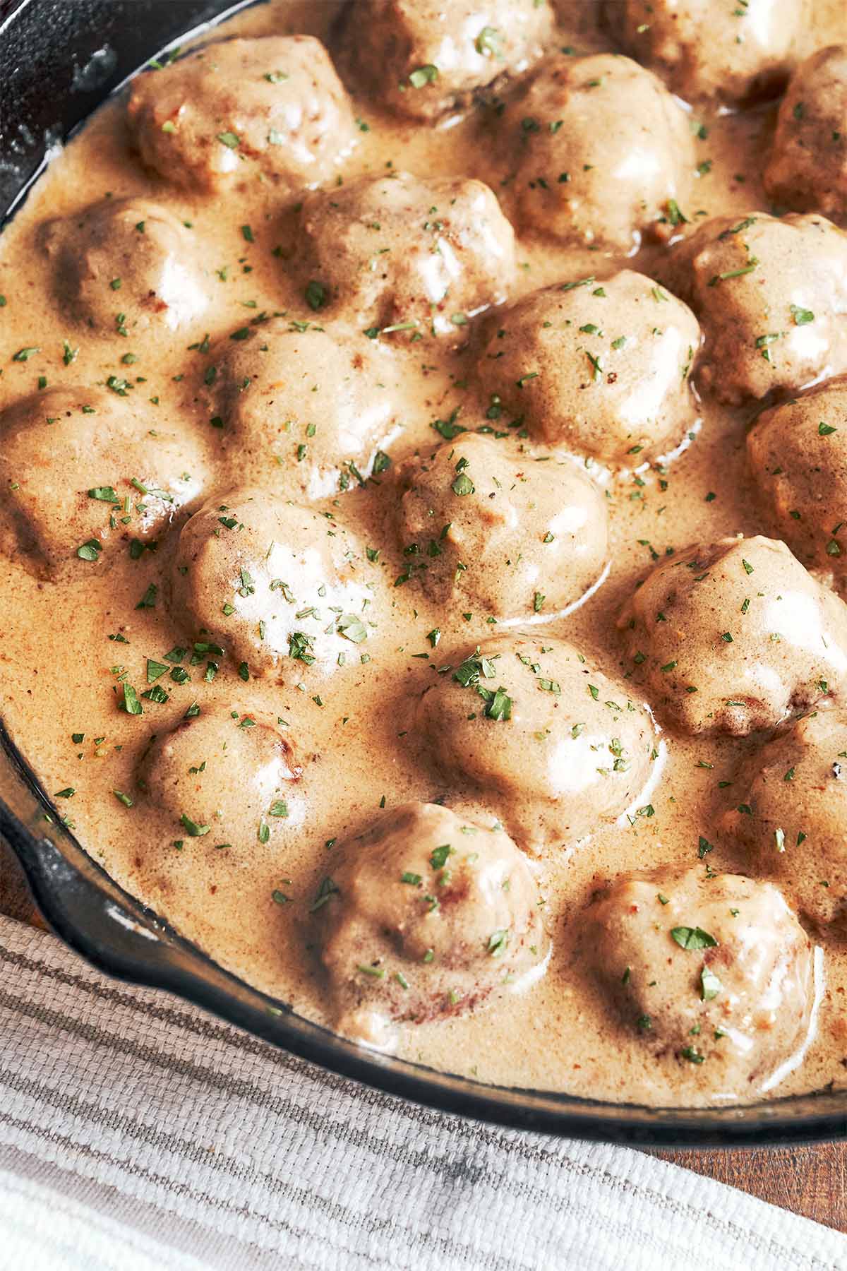 Juicy meatballs nestled in a rich, silky gravy with a little parsley on top