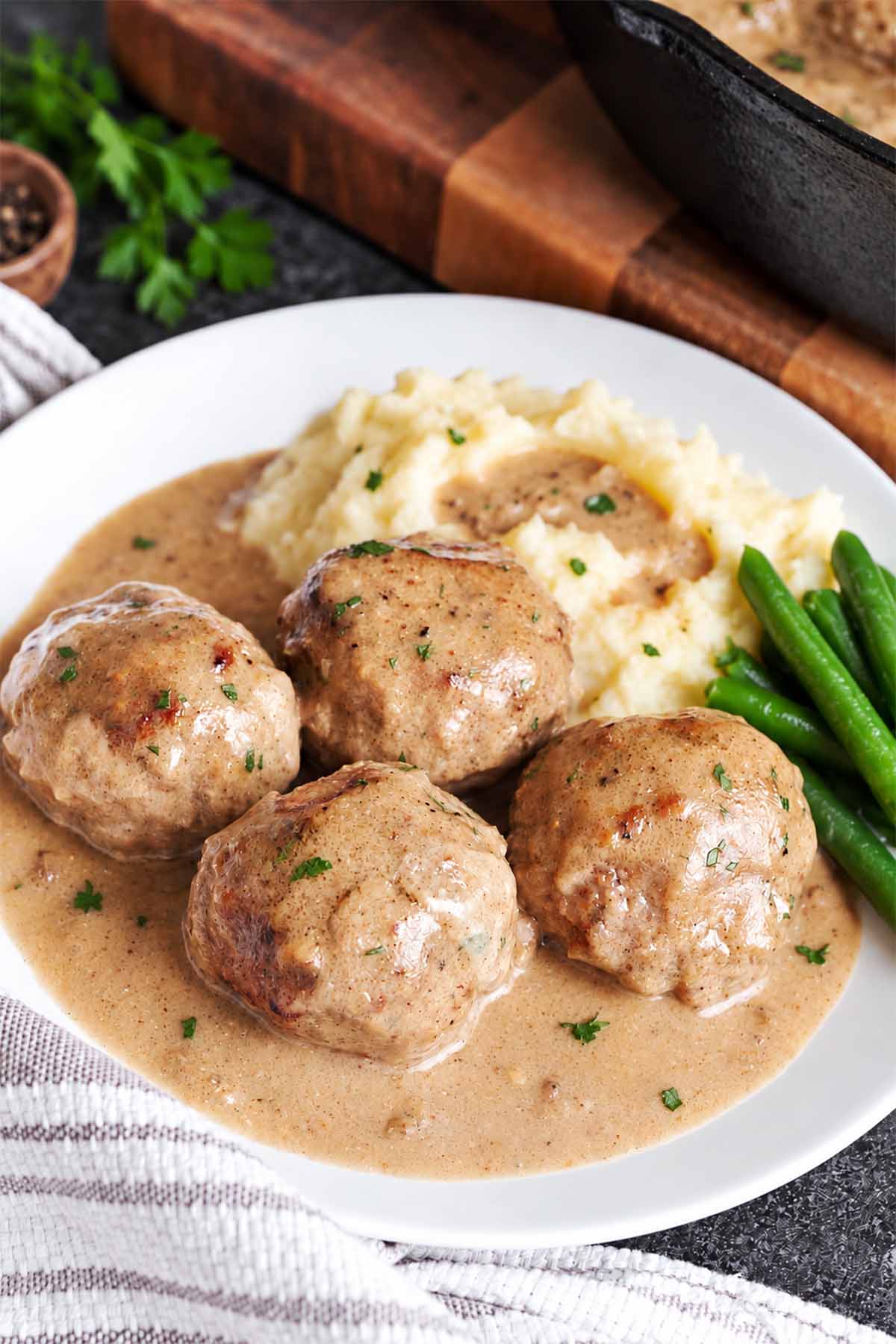 Tender meatballs in creamy gravy with mashed potatoes on the side