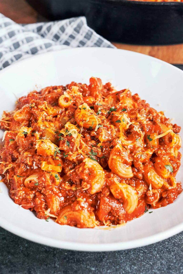 American goulash with ground beef and elbow macaroni in a rich tomato sauce, finished with melted cheddar and parsley.